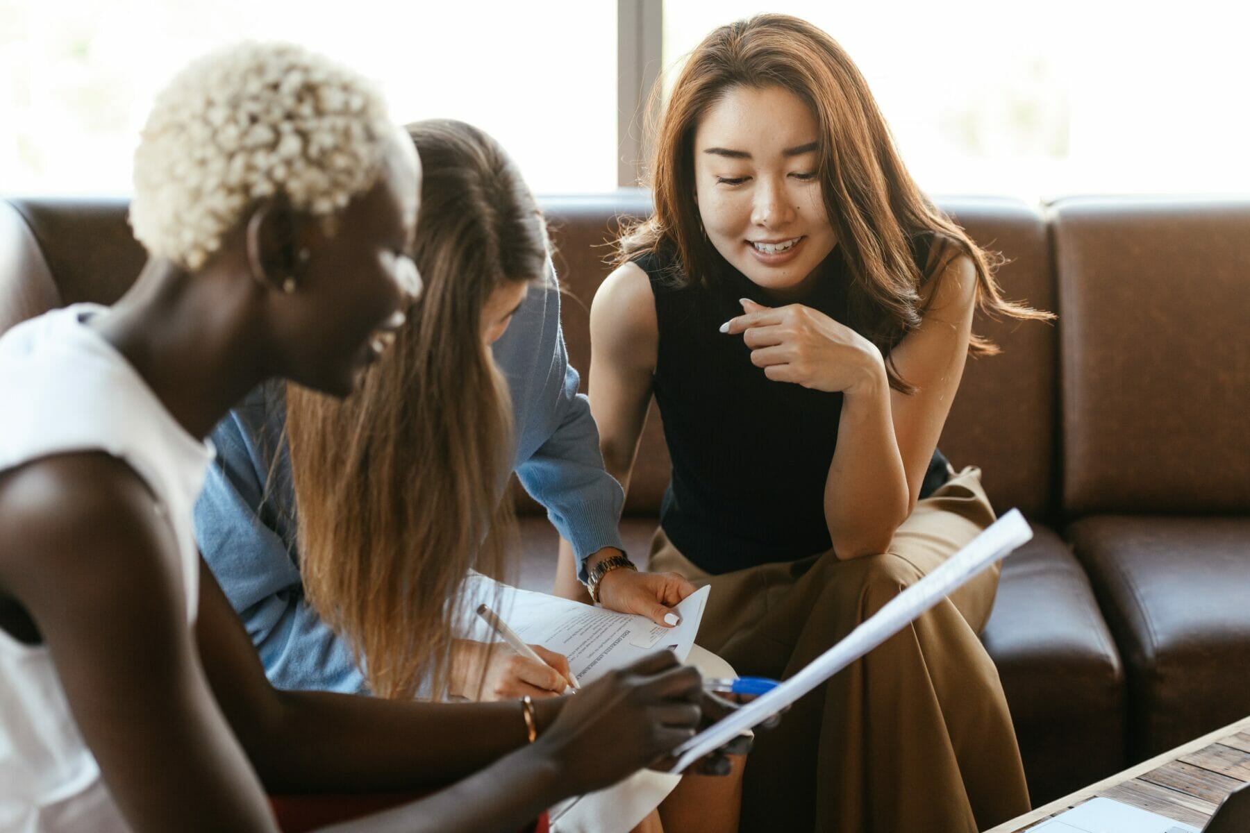 the-4-disc-personality-types-three-young-women-smiling-while-talking-about-a-project